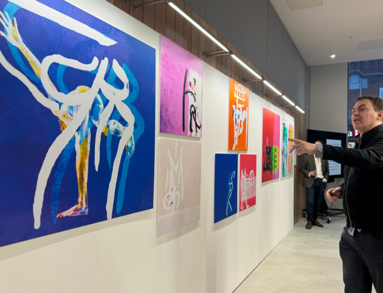 Peter Constantine standing in front of some pieces from the Lost Wor(l)ds exhibition